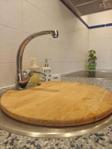 a wooden cutting board sitting on top of a kitchen sink at Premium Apartment in Antigone Luxury and comfort in Montpellier +51 photos