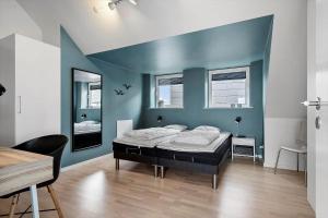 una camera da letto con un letto e una parete blu di 799-Hvide-Sande-Strandgade-6-Lejl-6 a Hvide Sande