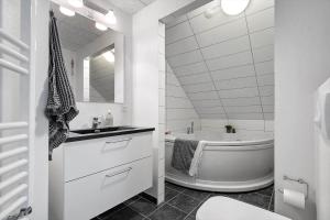 un bagno bianco con vasca e lavandino di 799-Hvide-Sande-Strandgade-6-Lejl-6 a Hvide Sande Altre 36 foto