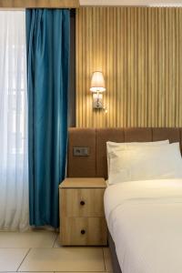 a bedroom with a bed and a blue curtain at Nani City Hotel Self Check-In in Zurich +32 photos