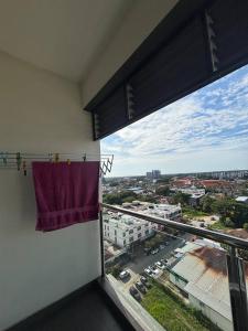 a balcony with a window with a view of a city at Centria Stay D'Perdana Apartment in Kota Bharu