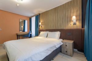 a bedroom with a large white bed and a desk at Nani City Hotel Self Check-In in Zurich