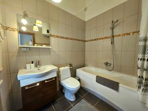 a bathroom with a toilet and a sink and a tub at Avocado Old Town 2BR Spacious Apartment near Dome Square in Rīga +30 photos