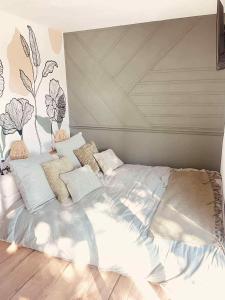 a bedroom with a large bed with white sheets and pillows at Le Temps d'une Nuit 