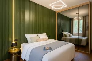 a bedroom with a large bed and a green wall at Les Maisons d Anthony Marseille in Marseille +27 photos