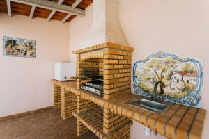 eine Küche mit einem Steinofen mit Spüle in der Unterkunft Best Houses 47 - Consolação Beach House in Atouguia da Baleia