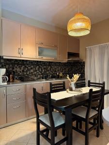 Polisi i VogëlにあるAb apartamentのキッチン(ダイニングルームテーブル、椅子付)