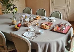 a table with food and baskets of bread on it at Château de la Saulinière in Kain