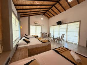 a bedroom with two beds and a table and chairs at Ele Camp Udawalawe in Udawalawe