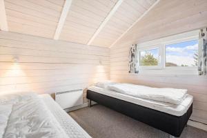 a bedroom with two beds and a window at 555-Hvide-Sande-Tornbjerrevej-32 in Havrvig