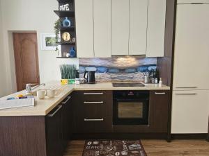 a kitchen with white cabinets and a stove top oven at Avocado Old Town 2BR Spacious Apartment near Dome Square in Rīga