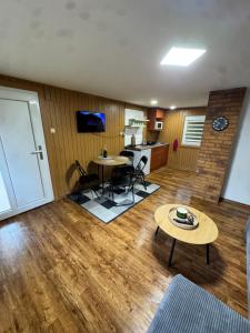 a living room with a table and chairs and a kitchen at Chata Hugo in Česká Lípa