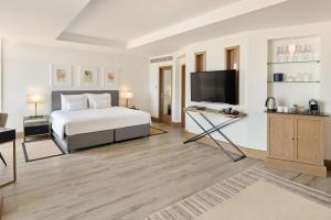 迪拜JA Beach Hotel, Dubai的一间带床和平板电视的卧室
