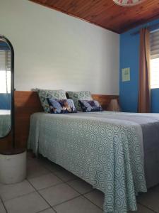 a bedroom with a bed with a green and white blanket at Appartement moderne avec vue mer à Le Vauclin, 55 m² in Le Vauclin