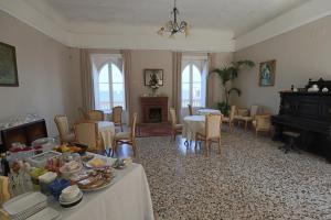 a living room with tables and chairs and a piano at B&B Villa Raineri in Giardini Naxos