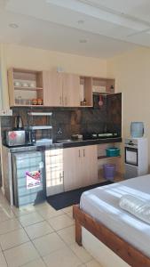 cocina con fogones y 1 cama en una habitación en Diani Savanna Sunset Studio Apartment, en Diani Beach