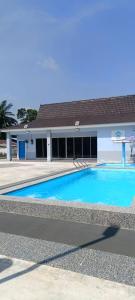 a large blue swimming pool in front of a building at Villa Atok Opah in Teluk Intan
