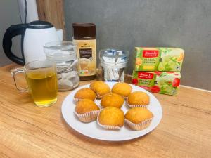 a plate of muffins on a table with a glass of beer at Grand Hostel - Free Breakfast in Katowice