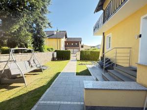 a yard with a swing and a house at Appartement Schwanenstadt in Oberndorf bei Schwanenstadt