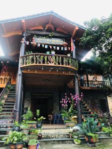 a building with stairs and potted plants in front of it at Khuổi Ky Eco Homestay in Cao Bằng