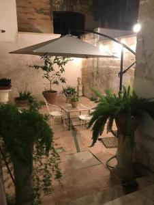 a patio with an umbrella and chairs and plants at Il Cortile Di San Lazzaro Lecce in Lecce