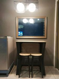 escritorio con taburete y TV en la pared en El Cozy Woody Near Enchanted Kingdom, en Santa Rosa