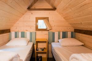 Un dormitorio con dos camas en una cabaña de madera. en les cabanes du tertre, en Cour-Cheverny