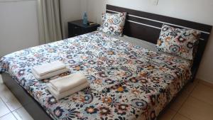 a bedroom with a large bed with a floral comforter at Unique City room in Larnaca