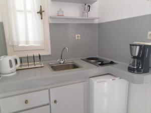 a white kitchen with a sink and a blender at Nikoleta's Studios in Drios