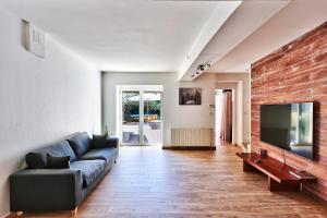 a living room with a couch and a flat screen tv at Le gite du pilot in Soucieu-en-Jarrest