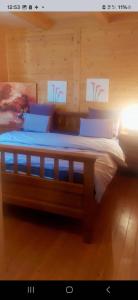 a bedroom with a bed with a wooden wall at Etno Eko Kuća S&S 