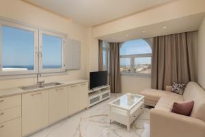 a kitchen and living room with a couch and a tv at Azure Bliss in Karterados