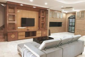 a living room with a couch and a flat screen tv at Cozy Johor Bahru Home with Family Room and unblock balcony View in Johor Bahru