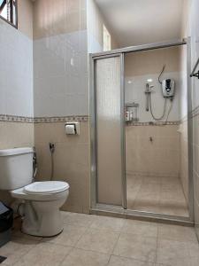 a bathroom with a toilet and a glass shower at Cozy Johor Bahru Home with Family Room and unblock balcony View in Johor Bahru