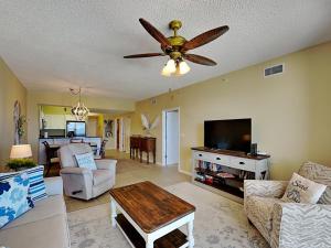 a living room with a ceiling fan and a television at Windemere #606 in Perdido Key