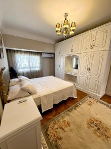 a bedroom with a bed and a chandelier at Abdulaziz Al Saud Street - Panoramic Nile-Pyramids view 3BR Apartment in Cairo