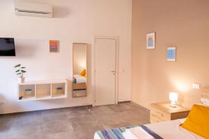 Una habitación con un dormitorio con una cama y un espejo. en Olivia Mare, en Marina di Pisa
