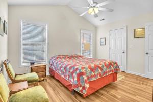 a bedroom with a bed and a ceiling fan at Island Delight by Oak Island Accommodations in Oak Island