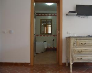 a hallway with a mirror and a dresser in a room at Quinta dos Tesouros in São Brás de Alportel