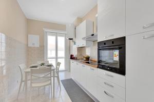 a kitchen with white cabinets and a small table at Casa Torino - Rho Fiera Stay in Rho +15 photos