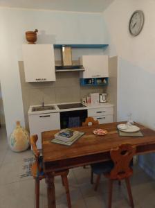 a kitchen with a wooden table and a kitchen with a clock at GIARDINI DI MARZO Casa vacanza in Poggio Bustone