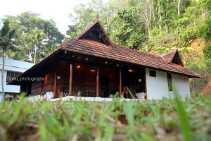 a small house with a brown roof at Poovar Heritage Homes in Pūvār