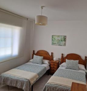 sypialnia z dwoma łóżkami i lampą w obiekcie APARTAMENTOS PASEO DE LORDELO - 2 Izquierda w mieście O Grove