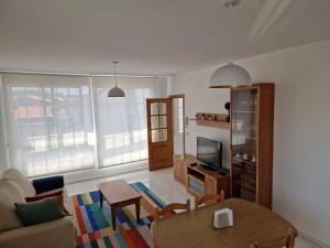 salon ze stołem i telewizorem w obiekcie APARTAMENTOS PASEO DE LORDELO - 2 Izquierda w mieście O Grove