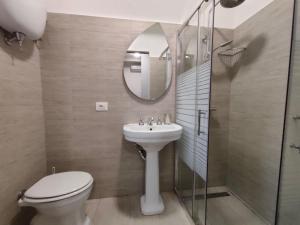ein Badezimmer mit Waschbecken, Toilette und Spiegel in der Unterkunft Orizzonte - Castiglione del Lago in Piana