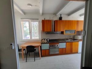 eine Küche mit Holzschränken, einem Tisch und einem Fenster in der Unterkunft Orizzonte - Castiglione del Lago in Piana + 4 Fotos