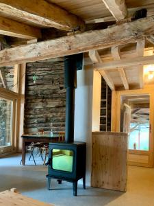 Un televisor en una habitación con chimenea. en Appartement - Saint Véran, en Saint-Véran