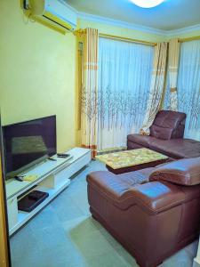 een woonkamer met een bank en een flatscreen-tv bij New Park Resort in Mahajanga