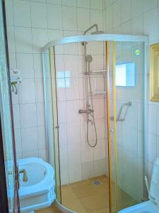 een badkamer met een douche, een bad en een wastafel bij New Park Resort in Mahajanga