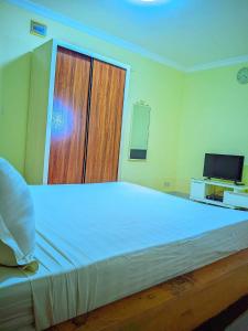 een slaapkamer met een groot bed en een televisie bij New Park Resort in Mahajanga